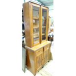 An Aesthetic period mahogany glazed cupboard with three shelves, the base with two drawers over