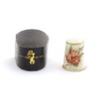 A porcelain thimble with hand painted floral detail, within a fitted case. Thimble approx. 1" high