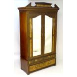 An early 20thC Art Nouveau style walnut wardrobe, with a moulded pediment above a dentil moulded