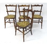 A set of four beech and walnut dining chairs with upholstered seats. Approx. 31 1/2" high overall (