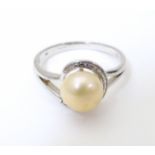 A .925 silver ring set with central pearl . Ring size approx R. Please Note - we do not make