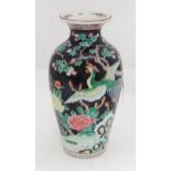 An Oriental vase decorated with a peacock in a landscape with flowers. Approx. 9 3/4" high Please