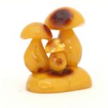 A late 19th / early 20thC amber carving modelled as a group of three toadstools. Approx. 2" high