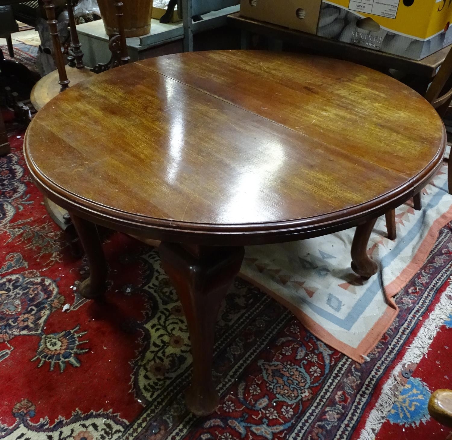 A mahogany oval dining table with cabriole legs and pad feet. Please Note - we do not make reference