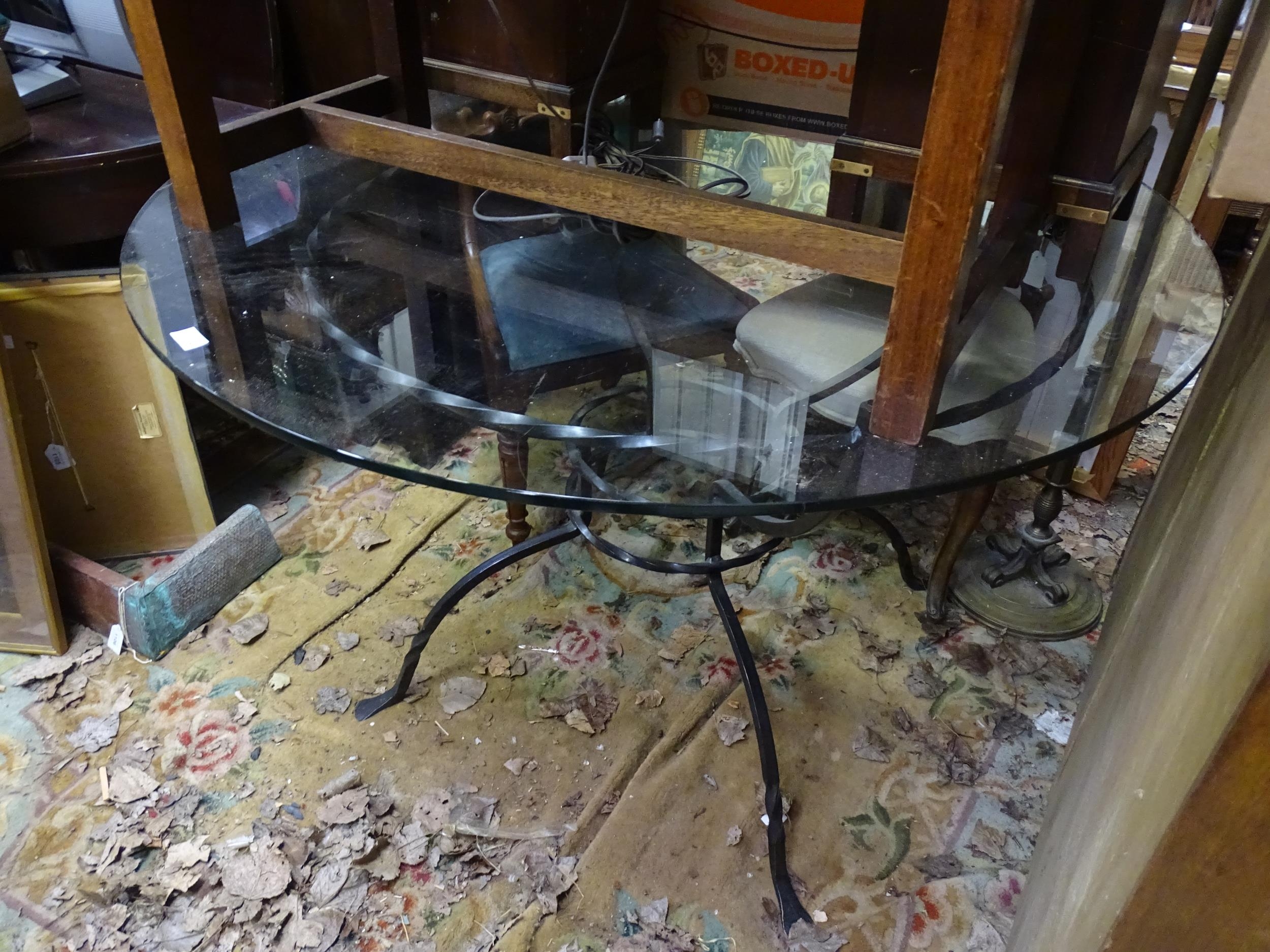 A 20thC circular glass topped dining table with a cast metal base. Approx. 47 1/2" diameter x 29" - Image 2 of 2