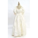 Vintage clothing / fashion: A c1980s ivory coloured bridal / wedding dress with lace bodice and