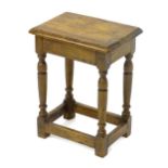 A late 19thC / early 20thC oak joint stool with a moulded surround and standing on four turned