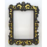 An early 20thC ebonised mirror frame with gilt highlights and foliate carvings. 61? high x 42?