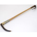 A late Victorian riding crop, with antler handle, white metal collar, malacca shank and leather