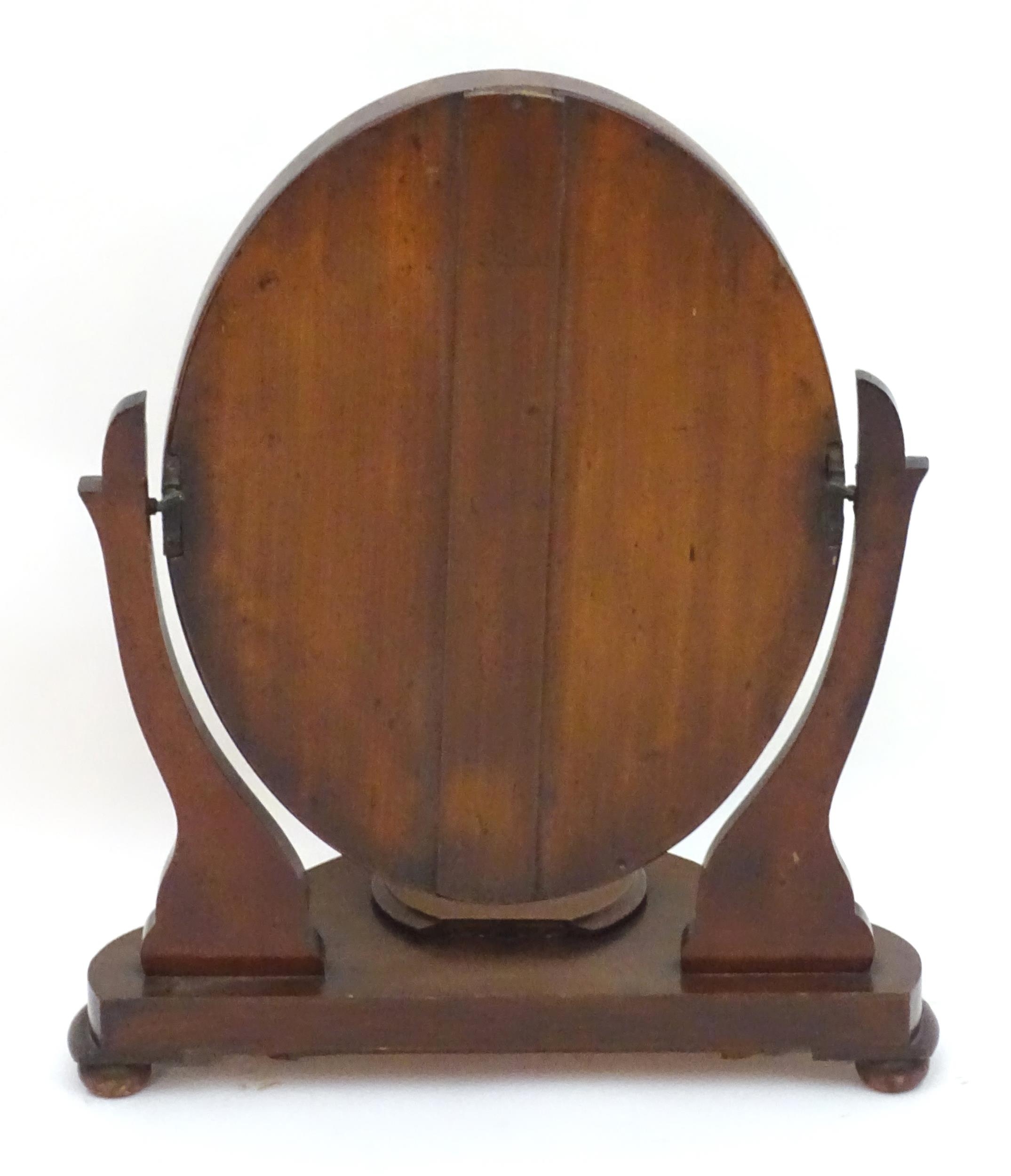 A Victorian mahogany toilet mirror with an oval mirror and shaped surrounds above a moulded base - Image 2 of 6