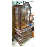 A glazed bookcase with bombe commode base. Approx 77" high x 33" wide x 20" deep Please Note - we do