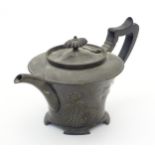 An Art Nouveau EPBM teapot with hammered decoration with embossed flowers and shield detail. Maker