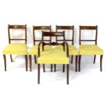 A set of five mahogany Regency dining chairs with reeded frames and swept arms above pierced mid