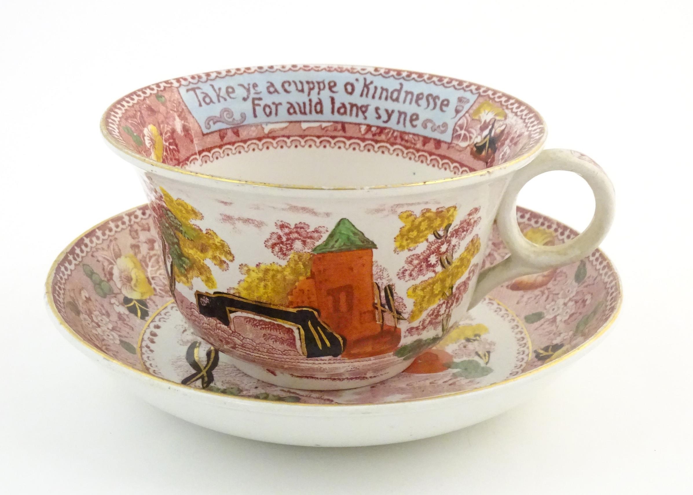 An oversized Burslem cup and saucer decorated with a bridge and tower in a landscape with the