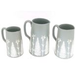 Three graduated jugs in the manner of Wedgwood with relief fern leaf and snowdrop flower detail.