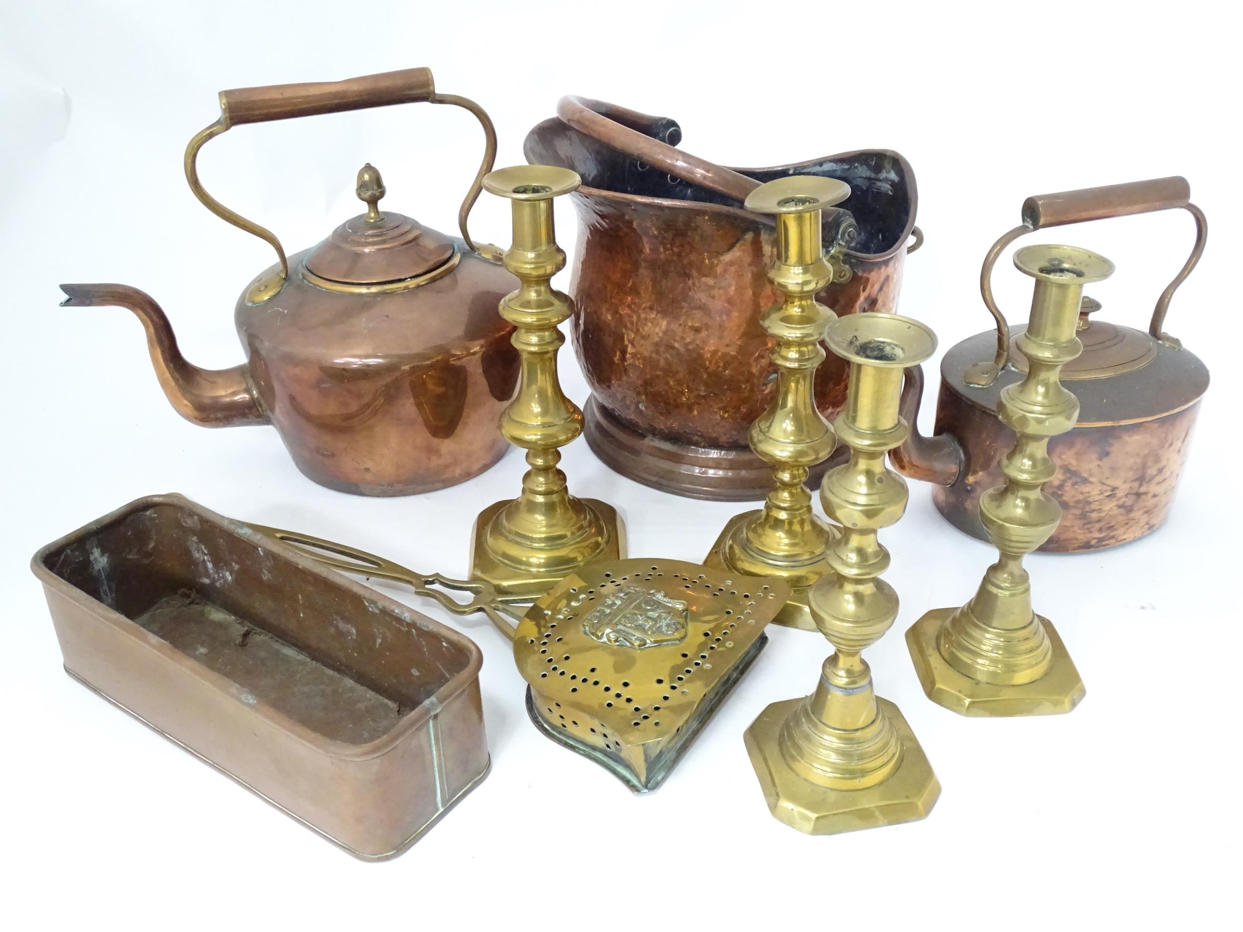 A quantity of brass and copper wares to include coal scuttle, kettles, copper pot, candlesticks,