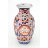 A Japanese vase decorated in the Imari palette with landscape scenes, flowers and foliage. Approx.