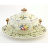 A French twin handled lidded tureen and stand with hand painted floral and foliate detail. Marked