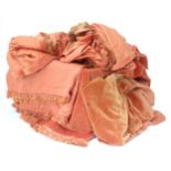 A quantity of peach / terracotta coloured fabric, counterpanes, etc. with fringe detail. Various