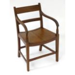 An early 19thC mahogany open armchair with shaped arms and reeded supports above squared tapering