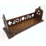 A 19thC carved oak Gothic book trough with lancet shaped uprights and carved foliate detail. Label