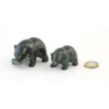 Two carved jade coloured hardstone models of bears, one with a fish in its mouth. Largest approx.
