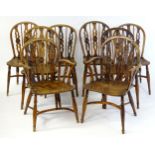 A set of eight C.1800 yew and elm Windsor chairs, having hoop backs and draught carved back splats
