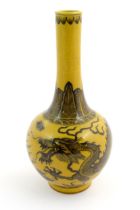 A Chinese bottle vase with a yellow ground decorated with a dragon amongst stylised clouds.