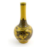 A Chinese bottle vase with a yellow ground decorated with a dragon amongst stylised clouds.