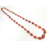 A white metal necklace of graduated carnelian stone beads. Approx. 30" long Please Note - we do