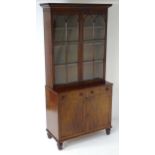 A late Georgian mahogany bookcase, having a moulded cornice above two astragal glazed doors