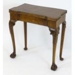 An early 20thC Georgian style walnut card table, having an inverted break front top above cabriole
