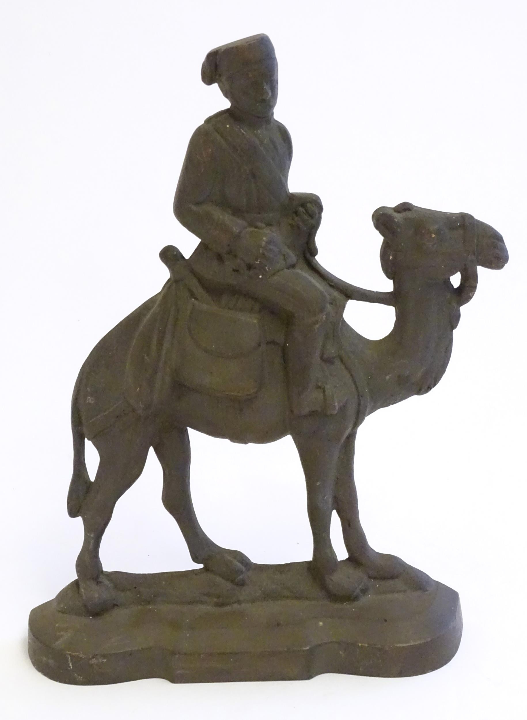 A 20thC cast door stop / door porter modelled as a man riding a camel. Approx. 11 1/4" high Please