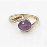 A 9ct gold ring set with central amethyst flanked by diamonds. Ring size approx. R Please Note -