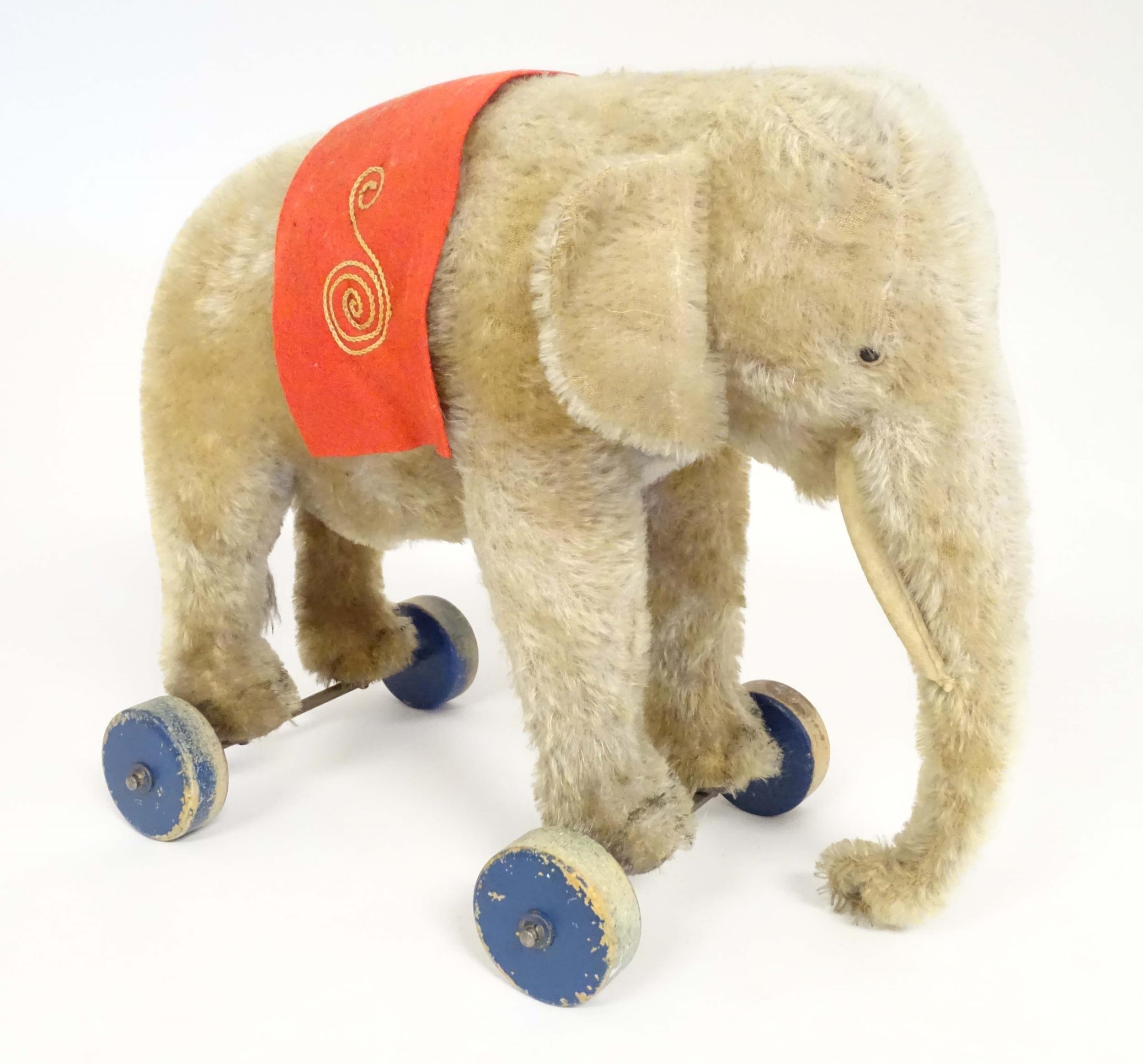 Toy: An early 20thC Steiff mohair pull along elephant toy with felt saddle, upon four wooden wheels, - Image 2 of 9