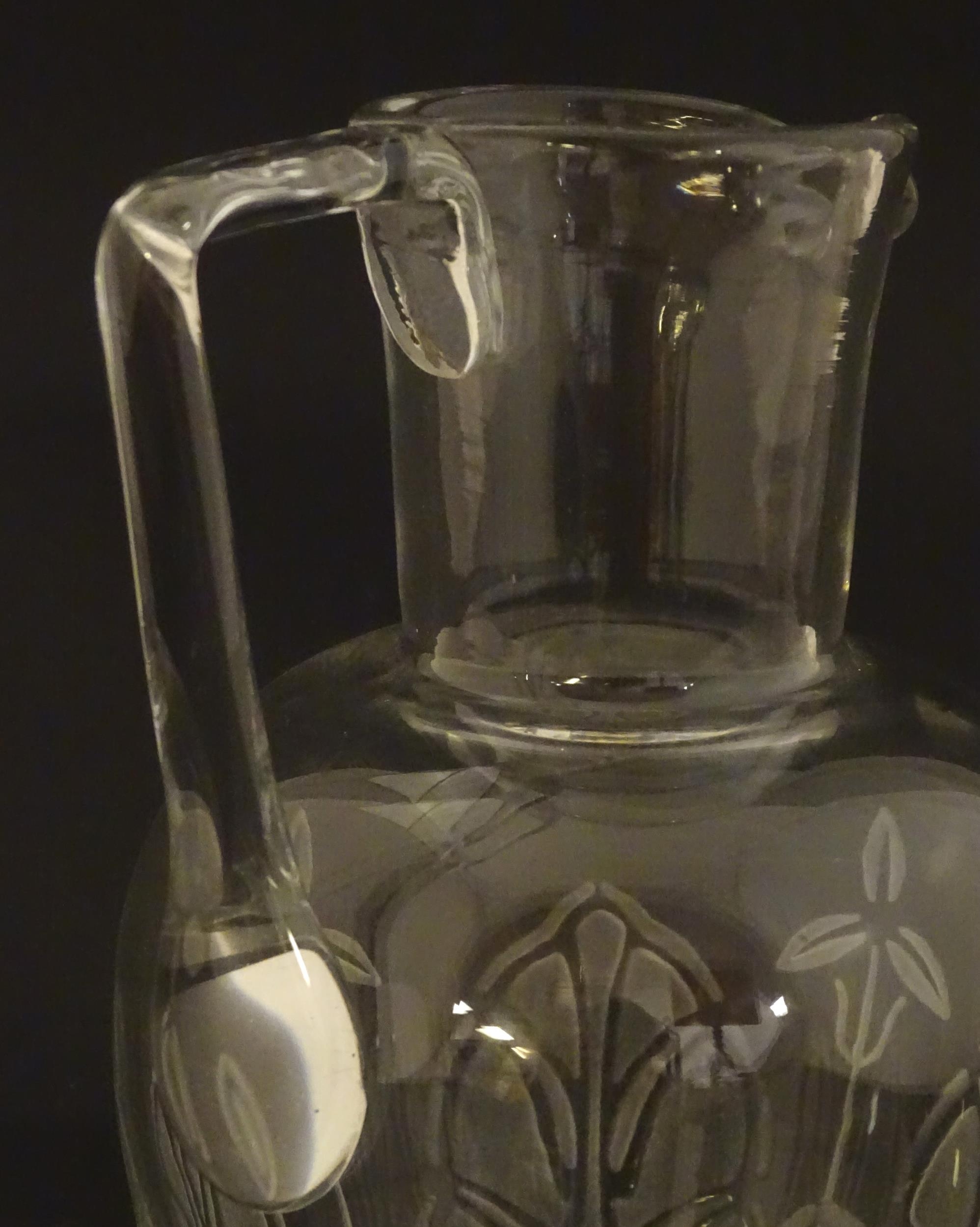 A glass water jug with foliate detail Approx 7" high Please Note - we do not make reference to the - Image 5 of 6