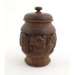 A Chinese wooden tobacco jar / pot and cover with carved decoration depicting stylised fish. Approx.
