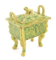 A Chinese rectangular censer with a yellow ground, raised on 4 paw footed legs, with twin upright