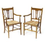 A pair of early 20thC mahogany elbow chairs with satinwood cross banded frames and pierced back