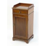 A 19thC mahogany pot cupboard / bedside cabinet with a shaped upstand above a small drawer and