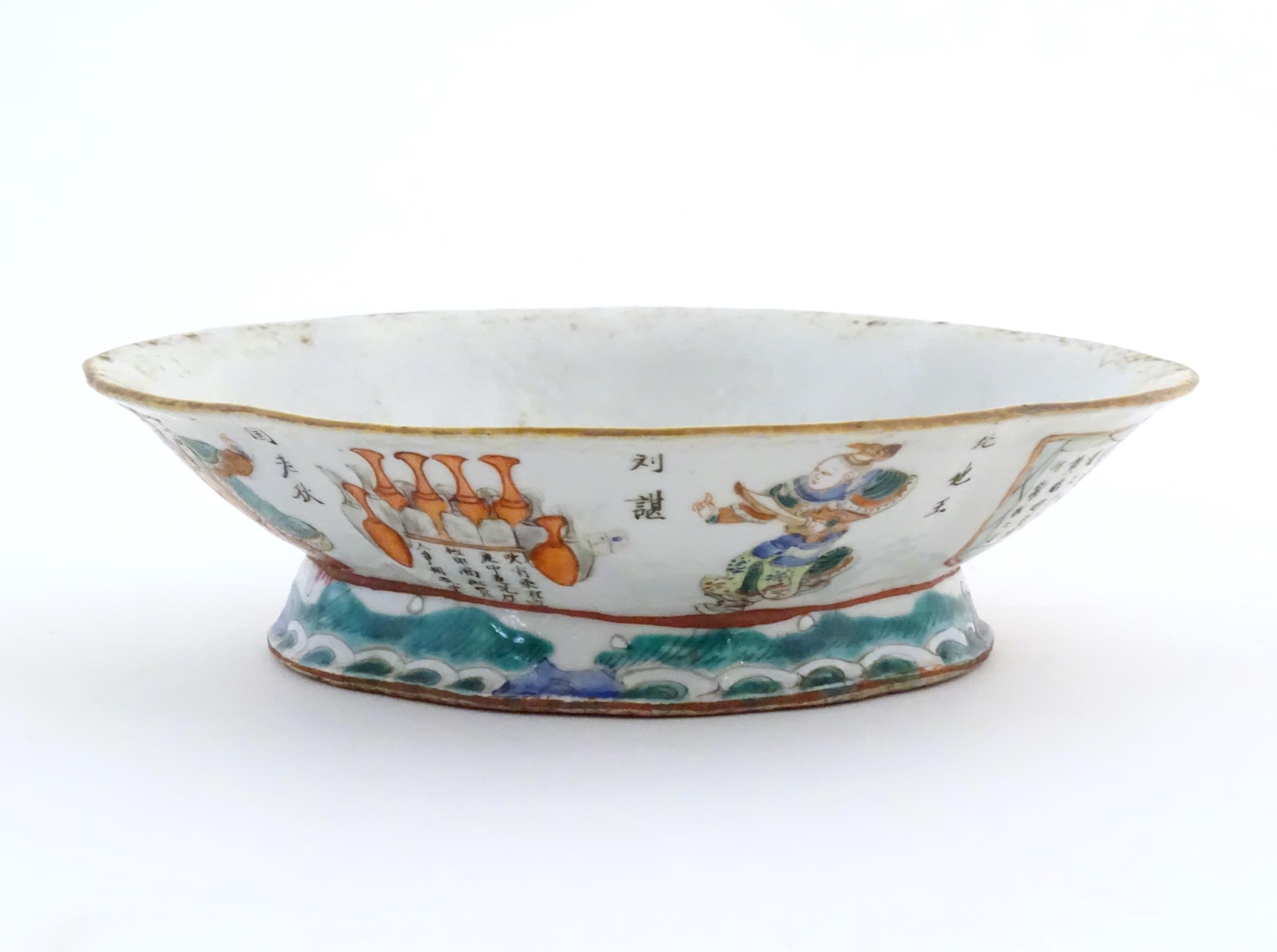 A Chinese footed bowl of lozenge form decorated with figures, vases and Character marks / script.