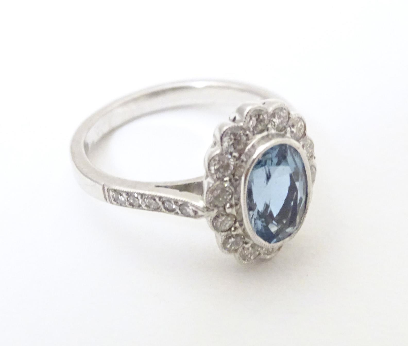 A 9ct white gold ring set with aquamarine coloured oval stone to centre bordered by diamonds with - Image 4 of 5