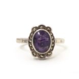 A silver ring set with blue john style cabochon bordered by marcasite. Ring size approx. M 1/2