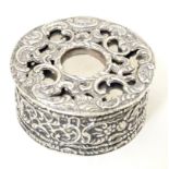 A Victorian silver and white metal box of circular form with hinge lid and scrolling foliate