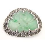 An Oriental brooch with carved jade detail within a silver mount. Approx. 1 3/4" wide Please