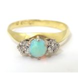 An 18ct gold ring set with an opal cabochon flanked by diamonds. Ring size approx. Q Please Note -