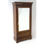 An early 19thC mahogany continental wardrobe of thin proportions, having a moulded cornice above a
