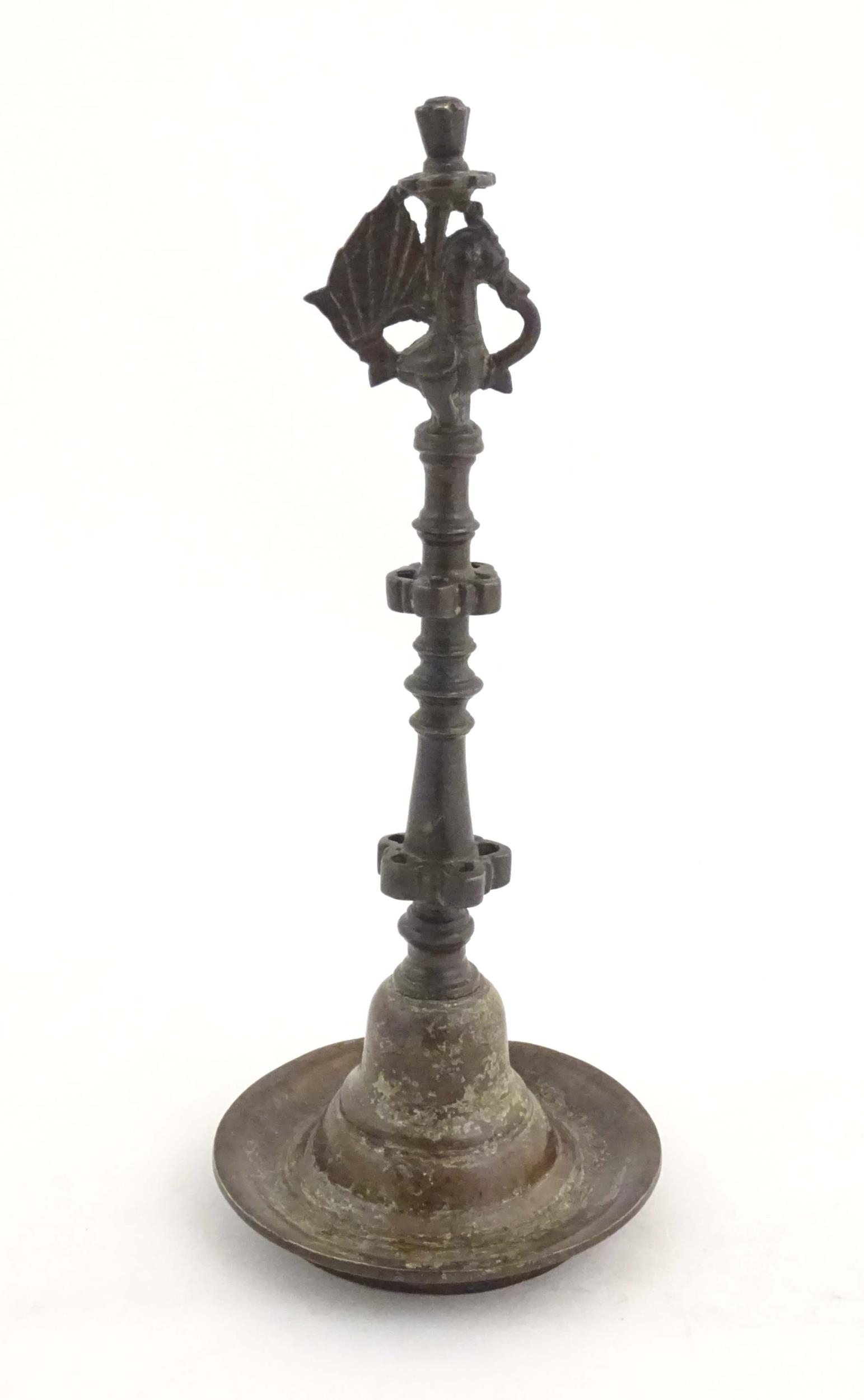 An Indian / Deccan cast temple style oil lamp with turned column surmounted by a Hamsa bird. Approx.