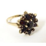 A 9ct gold ring set with garnets. Ring size approx R Please Note - we do not make reference to the