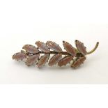An early 20thC gilt metal brooch of foliate form set with saphiret glass. Approx. 1 3/4" long Please